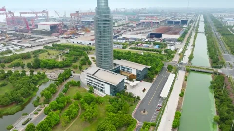 Museum tower and canal alongside a large shipyard in Shanghai Stock Footage 346584965