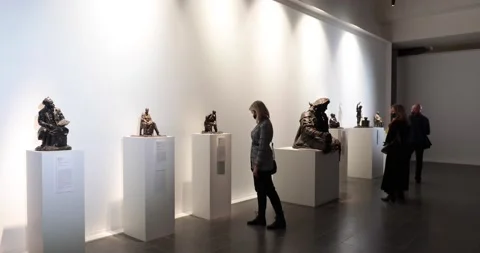 Museum visitors weared in face masks taking a tour at statue exhibition Stock Footage 152152134