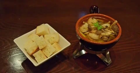 Mushroom and Shrimp Ajillo with Bread Cubes on Wooden Table, Restaurant Food 스톡 동영상 328620858