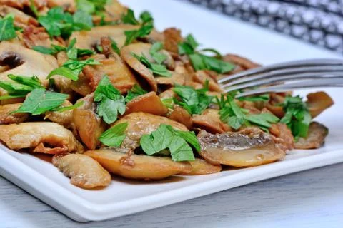 Mushroom in a plate with fork on table Stock Photos