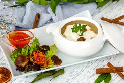 Mushroom soup in ceramic serving ware served with salad and sauce Stock Photos