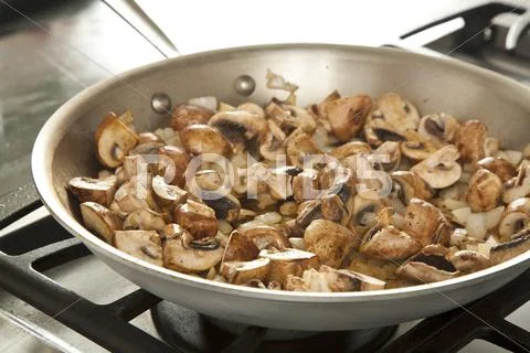 Mushrooms and Onions Cooking in a Skillet Stock Photos