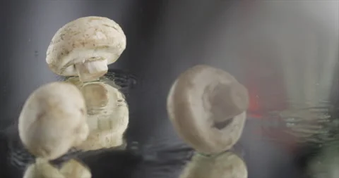 Mushrooms falling on a mirror surface Stock Footage 197866060