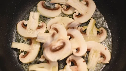 Mushrooms in the process of stewing and frying in a pan in butter Stock Footage 108204597