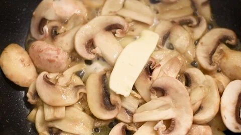 Mushrooms in the process of stewing and frying in a pan in butter Stock-Footage 108204937