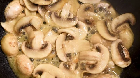 Mushrooms in the process of stewing and frying in a pan in butter Stock Footage 108205192