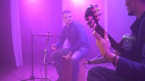 Music band performing on stage in different color light and smoke in background. Video stock 100716283
