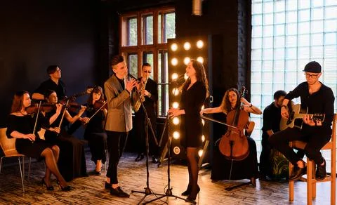 Music band with string quartet on the background of the loft interior Stock Photos