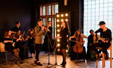 Music band with string quartet on the background of the loft interior Stock Photos
