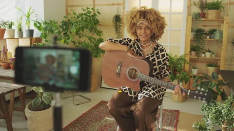 Music Blogger Making Tutorial How to Play Guitar at Room with Houseplants Stockbeeldmateriaal 255817937