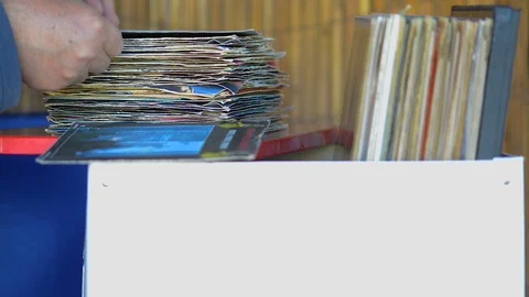 Music fan watches a stack of old 33 rpm vinyl records. A disc is carefully re 動画素材 120531709