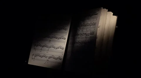 Music notes with ray of light, wind scrolls the sheet, on black Stock Footage 59906406