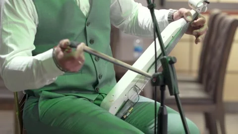 Music performance with a unique string instrument in a cozy setting Stock Footage 334545290