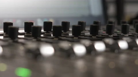 A music producer is turning knobs of an audio mixer, with blinking green 動画素材 131846801
