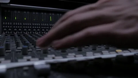 A Music Producer Tweaking Knobs on A Professional Analog Audio Mixer in a Studio Stock Footage 73114548