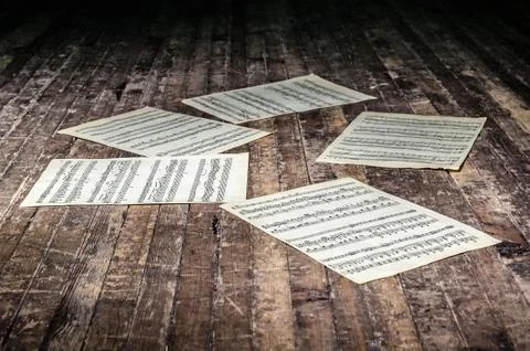 Music sheets with notes of a musical work lie on the old floor in the dark Foto stock