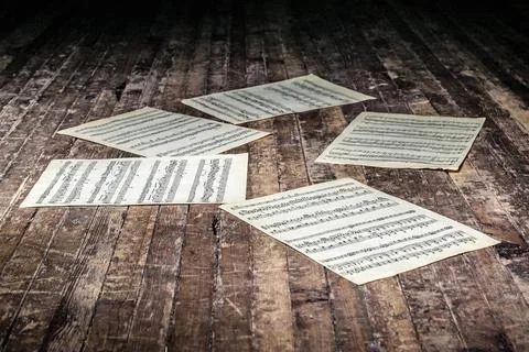Music sheets with notes of a musical work lie on the old floor in the dark... Foto stock