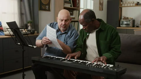 Music Teacher Explaining Notes and Melody to Senior African American Man Stock Footage 333421926