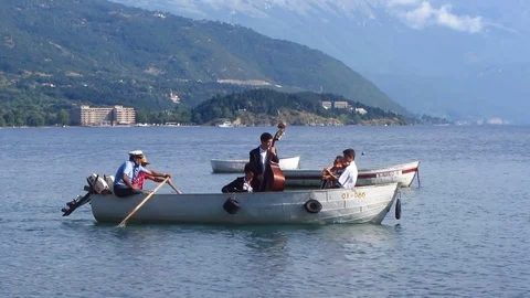Musical ensemble performing from a boat on a lake Stock Footage 80755063