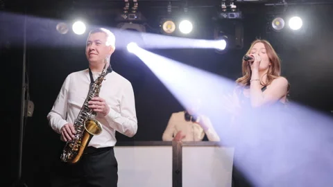 Musical group band of singer vocalist woman, saxophonist sax, dj man playing Stock Footage