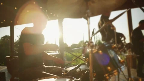 A musical group performs on an outdoor stage on a a summer sunset at a party Stock Footage 258754381