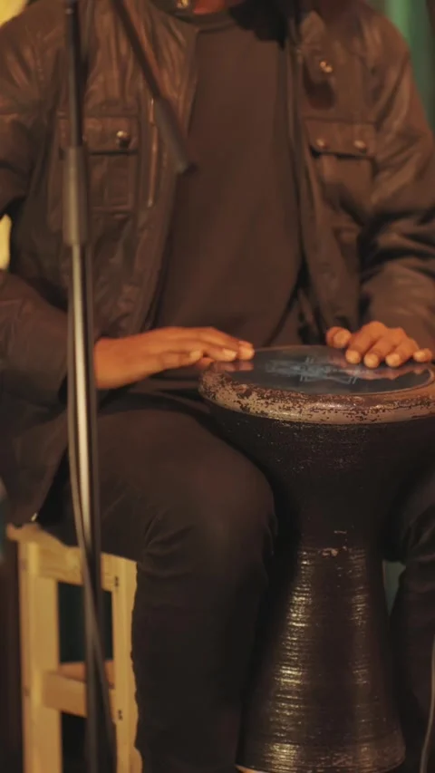 A musical group performs on stage in a bar - a man plays a bata instrument Stock-Footage 328419375