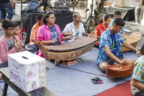 Musical group playing different instruments on city street in Phuket, Thailan Stock Photos