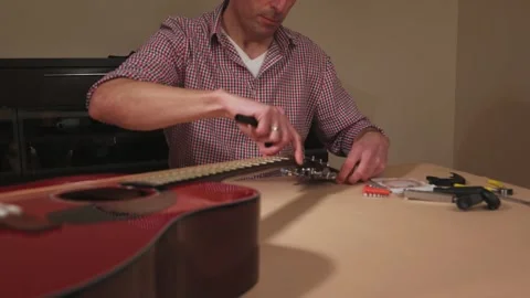 Musician Changing Strings and Repairing an Acoustic Instrument in Home Workshop Stock Footage 329023960