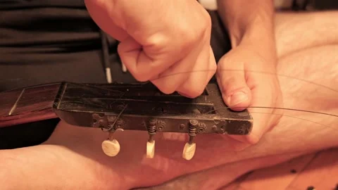 Musician changing strings on old classical guitar Stock Footage 341376321