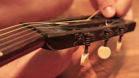 Musician changing strings on old classical guitar Stock Footage 341376533