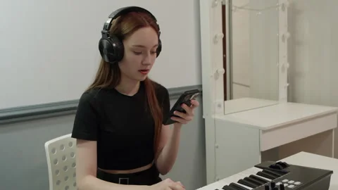 Musician composing music using smartphone and midi keyboard Stock Footage 301274628