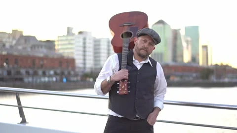 A musician looking at camera while holding his guitar on his shoulder Video stock 244553348
