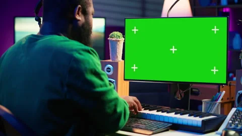 Musician operates on midi controller piano keys next to mockup screen Stock Footage 281375034