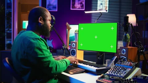 Musician operates on midi controller piano keys next to mockup screen Stock Footage 281377008