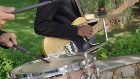 Musician performs energetic drum beats outdoors with guitar accompaniment Stock Footage 321444851