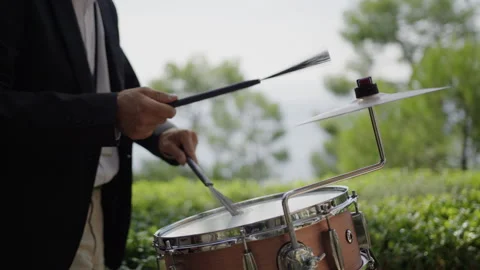 Musician performs energetic drum solo outdoors during sunny afternoon Stock Footage 321444685