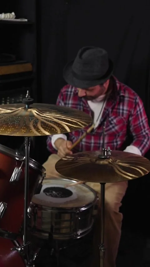A musician playing and practicing on a drum set in a rehearsal room Stock Footage 345089233