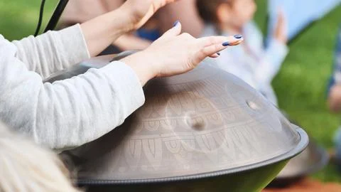 Musician playing a handpan with engraved patterns at India Day in Moscow Stock Photos