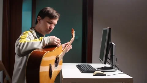 Musician plugging acoustic guitar into computer in home studio Stock Footage 308968181