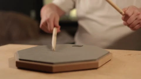 Musician practices drumming on a practice pad with sticks Vidéo 341737737