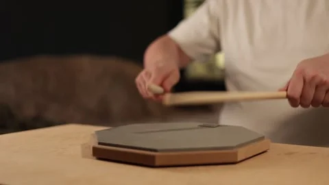 Musician practicing drumming on a practice pad with drumsticks Vidéo 341737515