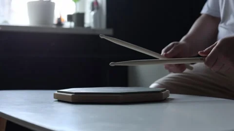 Musician practicing drumming on a practice pad with sticks Vidéo 341969108