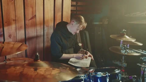 Musician practicing drumming techniques in a studio setting late at night Stock Footage 295331352