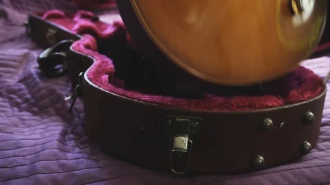 Musician is preparing for performance. Man put a guitar into a case Stock Footage 104394828