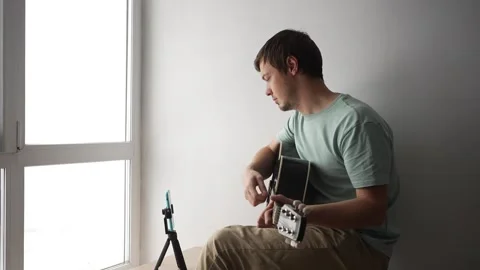 Musician recording guitar tutorial using smartphone 動画素材 294491777