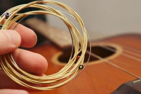 The musician replace the new guitar strings. The man's hand holding new mus.. Stock Photos