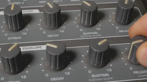 A musician turns the knobs of a synthesizer to adjust the sound. 動画素材 305091542