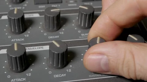 A musician turns the knobs of a synthesizer to adjust the sound. 動画素材 305091681