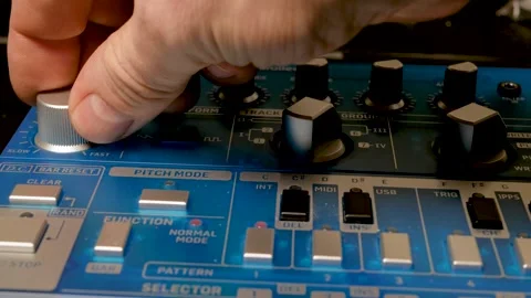 A musician turns the knobs of a synthesizer to adjust the sound. 库存影片 305247188