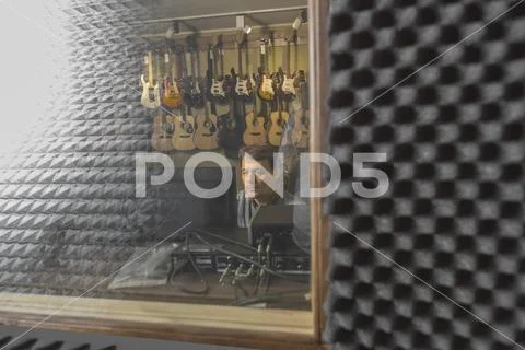 Musician using computer seen from window glass at recording studio Stock Photos